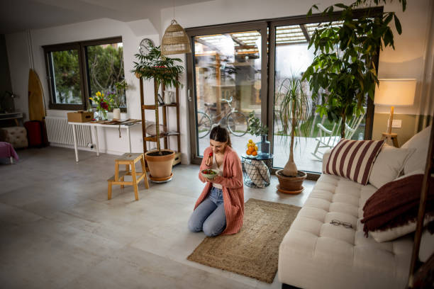 Photo of a young woman having healthy fruit snack in her living room