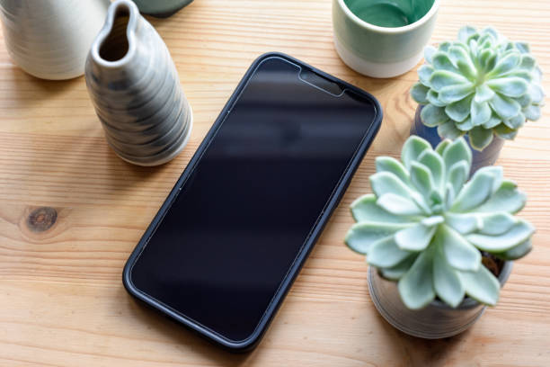 istock Blank mobile phone srceen on desk in overhead view 1392413044