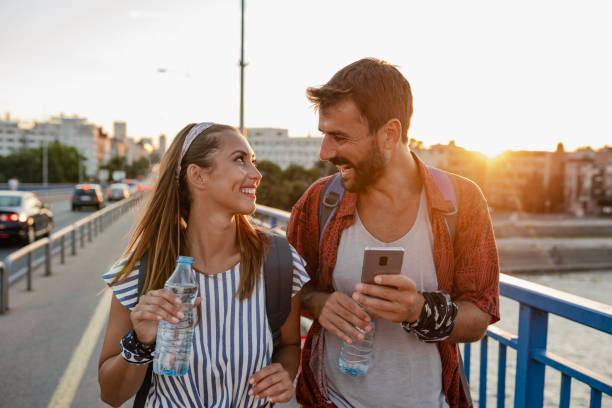 istock A young couple of tourists using mobile phone and walking 1392415018
