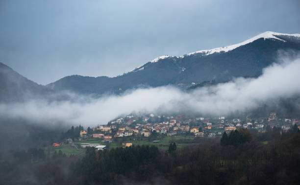 Mist clearing in the Italian Alps, revealing the village of Cerano d'Intelvi, in Como Province near the Swiss border.