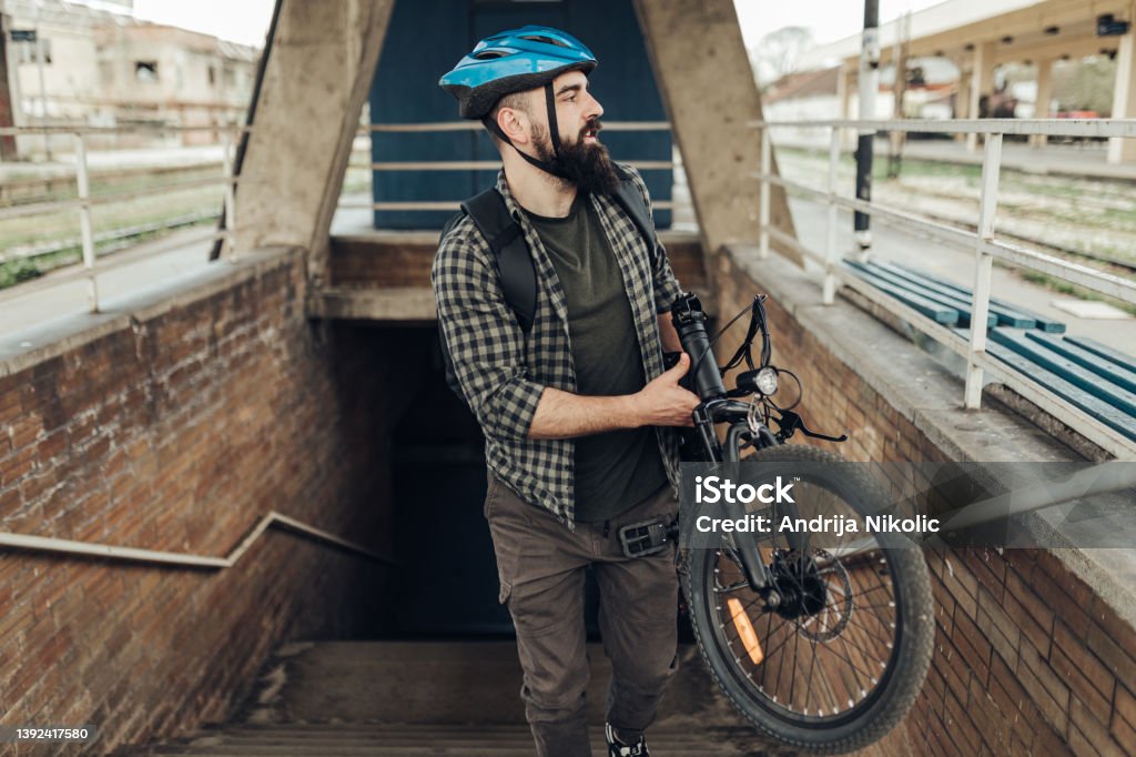 Commuter carrying his electric bicycle City Stock Photo