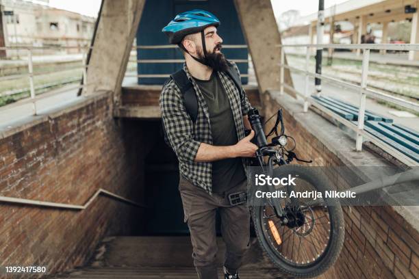 Commuter Carrying His Electric Bicycle Stock Photo - Download Image Now - City, Bicycle, Electric Bicycle