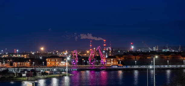 04/09/2022. Illuminated colourful old port cranes on a boulevard in Szczecin. City at night. Poland stock photo