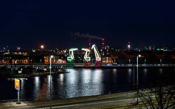 04/09/2022. Illuminated colourful old port cranes on a boulevard in Szczecin. City at night. Poland stock photo