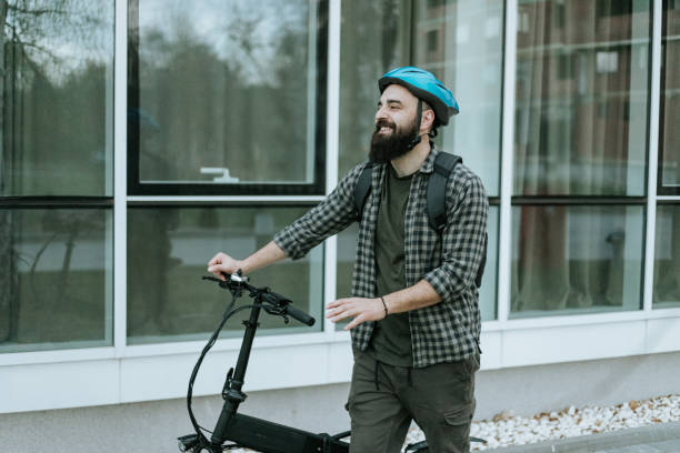 istock Commuter pushing electric bicycle and smiling 1392418477
