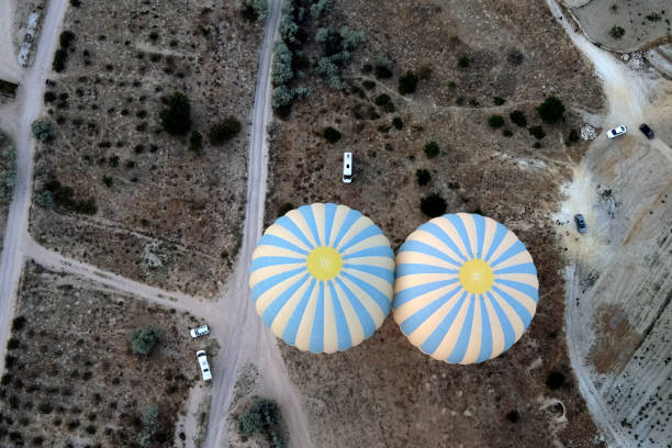 two colorful hot air balloons on ground stock photo