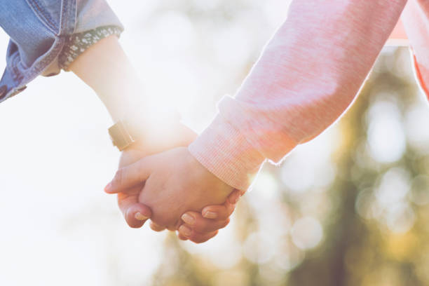 istock Parent and child holding hands closeup 1392421693