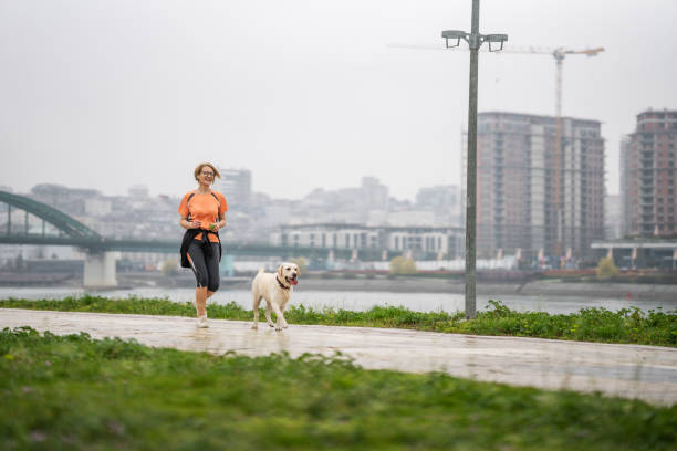 istock Woman jogging with her dog 1392427464