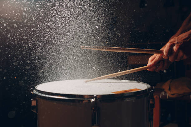istock Drum sticks drumming beat rhythm on drum surface with splash water drops 1392428857