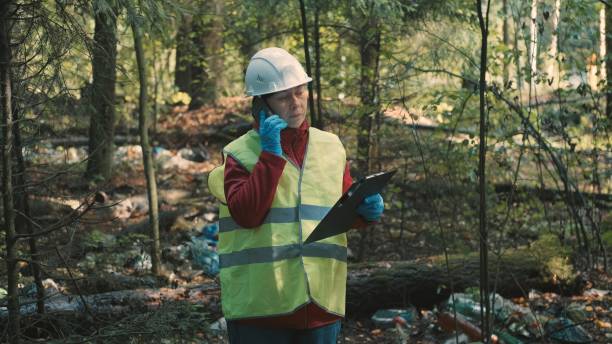 istock Ecologist woman in workwear issues fine for dumping plastic waste in park 1392428973