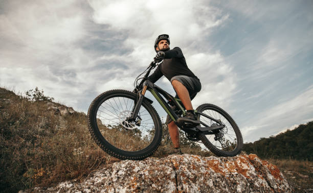 istock Confident cyclist with e bike in mountains 1392429034