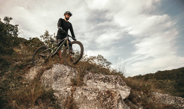 istock Bearded cyclist with bike walking down hill 1392429059