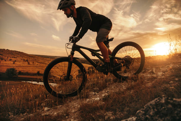 istock Active man riding mountain bike at sunset 1392429077