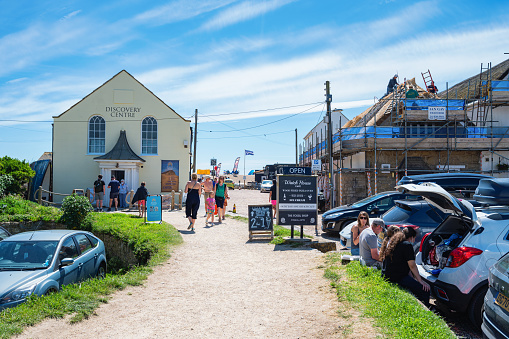 West Bay, United Kingdom - June 01, 2021. Bridport town and seaside parking, view of the houses and street cafes, selective focus