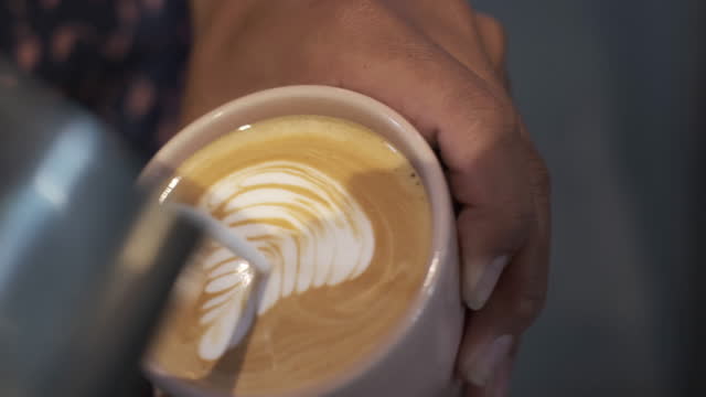 Unrecognizable Asian Male Barista Making Latte Art in Cappuccino