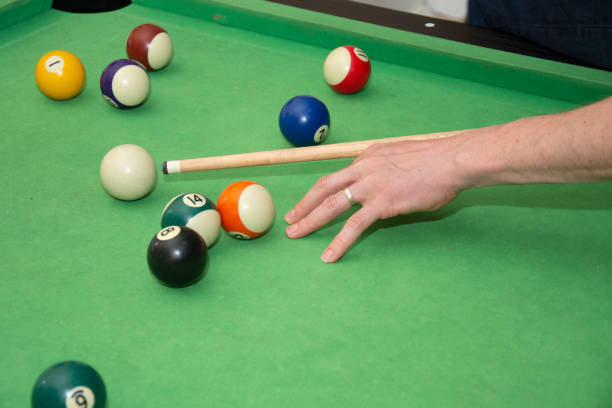 istock Hand with cue aiming on billiard ball at table 1392441471