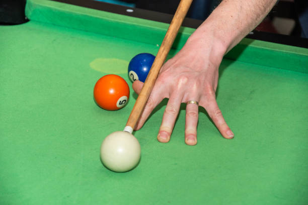 istock Hand with cue aiming on billiard ball at table 1392441547