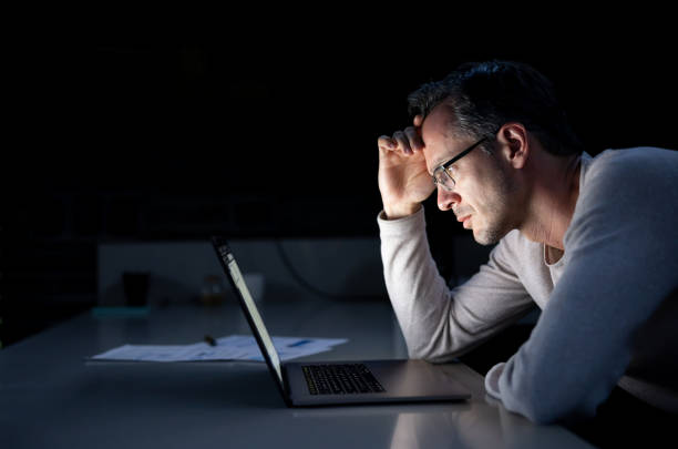 istock Man working late at home and looking worried 1392442626