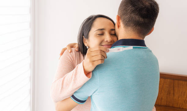 istock Happy couple hugs with a positive pregnancy test 1392444437