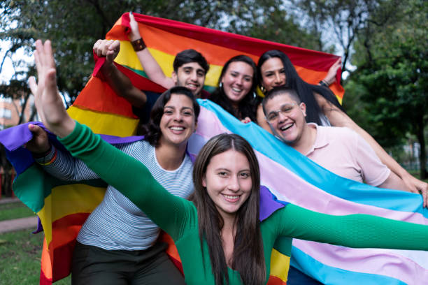 Portrait of happy and pride LGBTQIA group of friends holding a flag while facing camera smiling Portrait of happy and pride LGBTQIA group of friends holding a flag while facing camera smiling - LGBTQIA people lesbian pride stock pictures, royalty-free photos & images