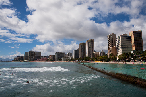 Oahu, Waikiki - August 27 2010 : View of people enjoying a Hawaiian beach with hotels at the background