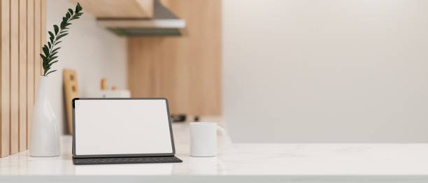 istock Minimal white kitchen countertop with copy space and a digital tablet mockup. 1392445453