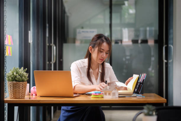 istock Young asian woman sitting in creative office and working with laptop computer. 1392445698