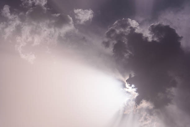 istock Black and white of sky with clouds and sunbeams 1392445794