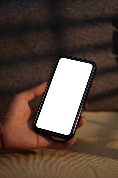 Young man holding mockup smart phone with white empty screen. Close up view. Young man holding mockup smart phone with white empty screen. Close up view. Iphone stock pictures, royalty-free photos & images