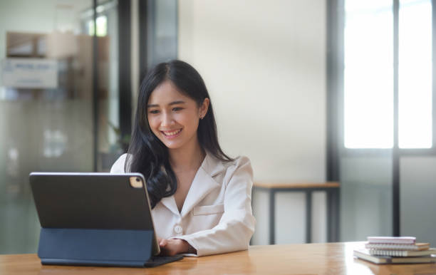 istock Pleasant young business woman checking financial data on computer tablet. 1392447384
