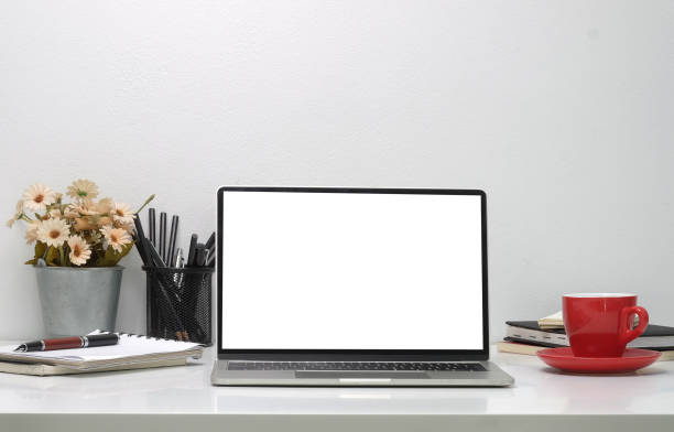 istock Home office desk with computer laptop, coffee cup, flower pot and notebook. 1392447389
