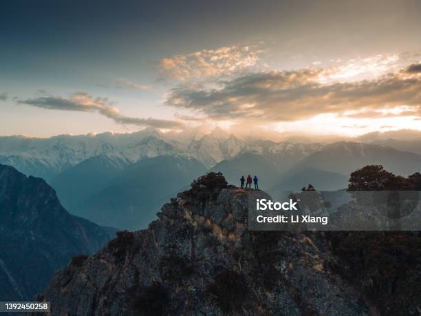 A Small Group Of People In Front Of A Snowcapped Mountain Stock Photo - Download Image Now