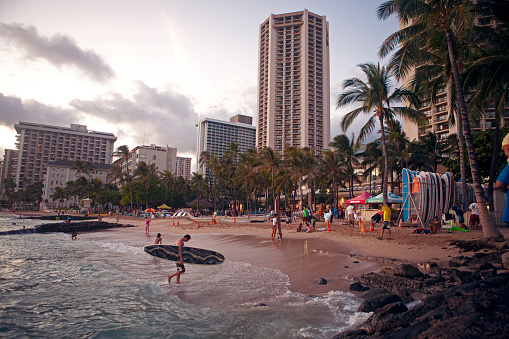 Honolulu - July 18, 2011 : View of man carrying a surfboard at Waikiki beach