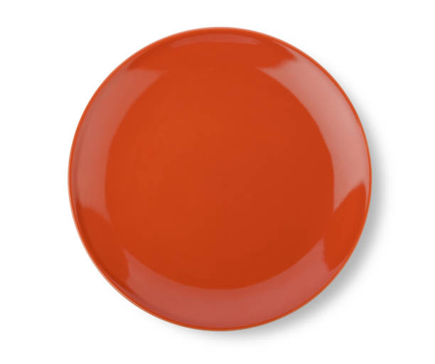 istock Orange ceramic plate isolated on white background. Top view 1392454493