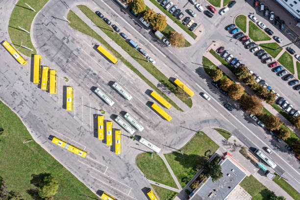 gare routière avec bus jaunes garés. transports en commun de la ville. vue aérienne depuis un drone volant. - traffic car street parking photos et images de collection