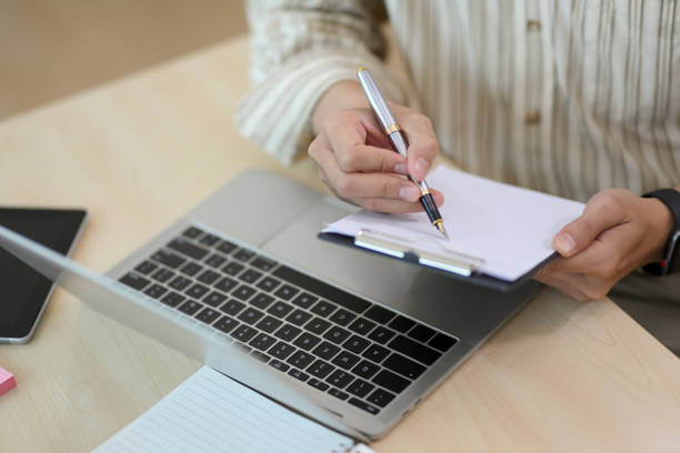 istock Close-up, Male office worker taking notes on clipboard 1392459534