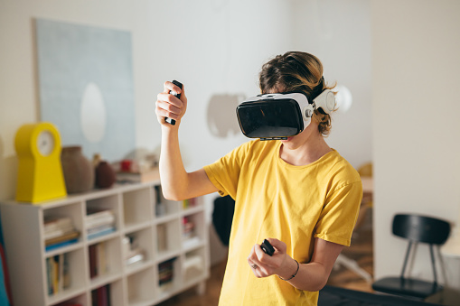 teenager boy using virtual reality glasses at home