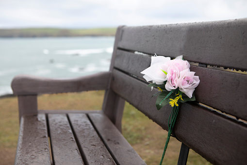 Remembrance to a loved one, on a bench covered in raindrops