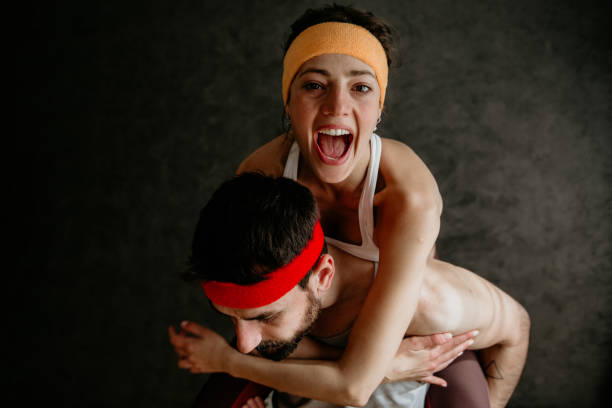 Get Fit. Waist-up shot of a young active man carrying a woman, both exercising during morning workout at home. Sport, healthy, fit lifestyle.