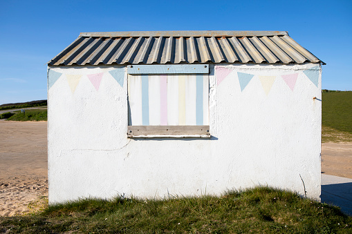 Small concrete hut, painted white, in a car park in Cornwall
