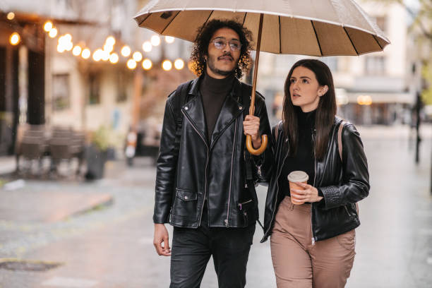 istock Mixed race couple walking under umbrella 1392470373