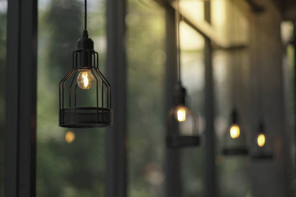 istock many vintage styles hanged ceiling lamp warm orange tone light color bulb light with blurred glass wall background 1392470595