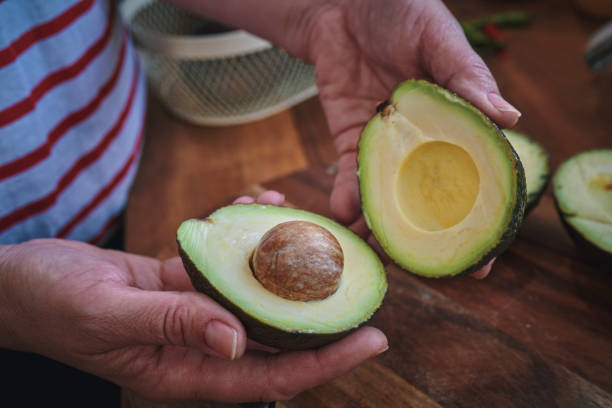 istock Cutting Avocado on Wooden Cutting Board 1392470615