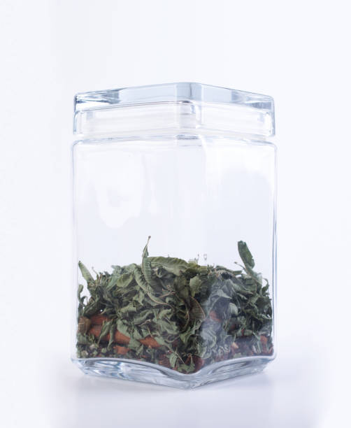 istock Dry mint in a glass jar isolated on white background. 1392470646
