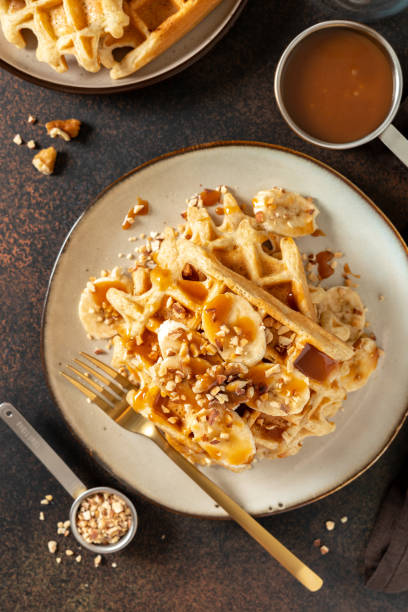 istock Banana waffles with walnuts and salted caramel in a plate on a culinary background 1392471161