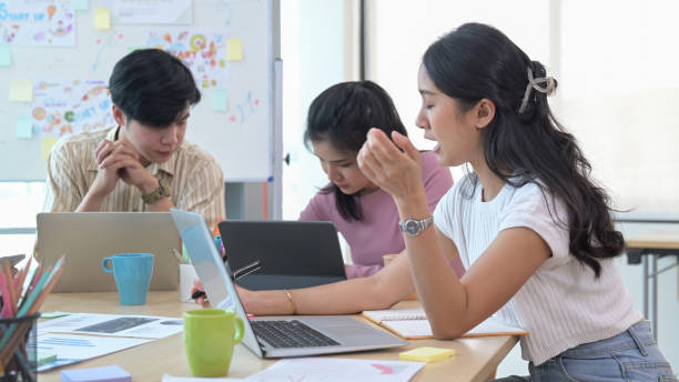 istock Young business team brainstorming and planning project strategy together at co working space. 1392472253