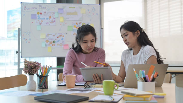 istock Two focused creative woman designers are working on design project together. 1392472305