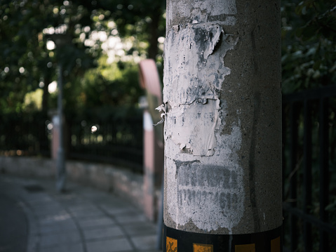 Worn posters on a pole at a narrow alley in Beijing, China.