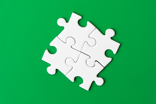 Concept of teamwork and partnership. Hands join puzzle pieces in the office. business people putting the jigsaws team together.Charity, volunteer. Unity, team business.