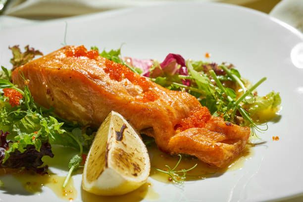 istock Salmon steak with lettuce and dressing in a plate. Selective focus 1392479863